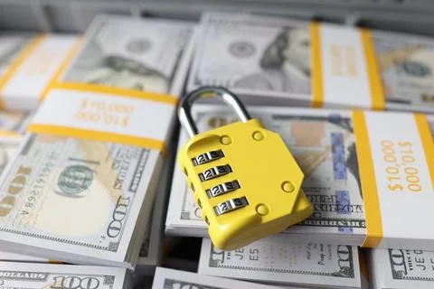 Yellow code lock on top of pile of cash Stock Photos