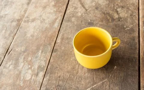 Yellow coffee cup on old wooden table Stock Photos