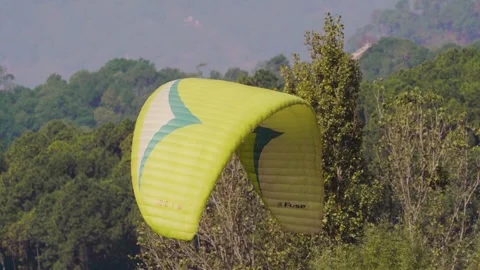 Yellow colored Parachute float down from the sky in Bir Billing, Himachal Stock Footage 256140747