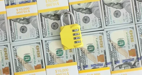 Yellow combination lock and a stack of hundred dollar bills Video stock 285481045