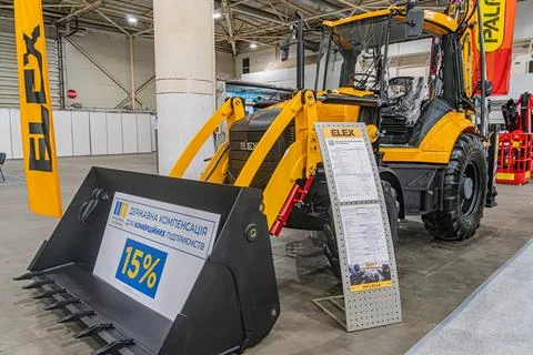 Yellow compact track loader with a bucket attachment, displayed in a construc Stock Photos