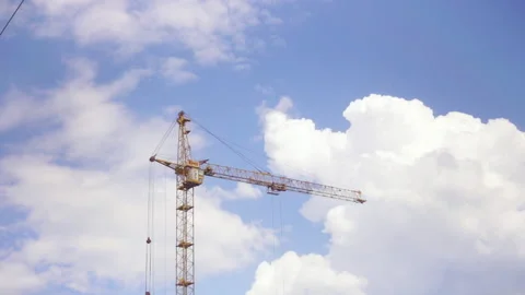 A yellow construction crane on blue sky cloudy background. Heavy construction Video stock 155955036
