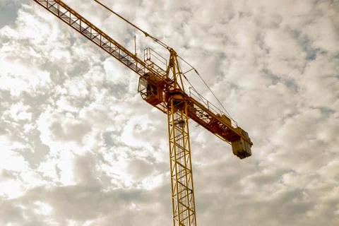 Yellow construction crane in cloudy sky Stock Photos