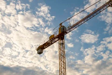 Yellow construction crane in cloudy sky Foto stock