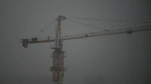 Yellow construction crane on sweeps with big snowflakes. Slow Motion. HD Stock Footage 74576652