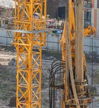 Yellow Construction Drilling Rig on Active Site with Urban Background Stock Photos