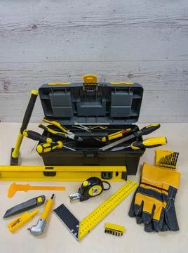 Yellow construction instruments and a tool box on a wooden background. Foto stock