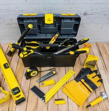 Yellow construction instruments and a tool box on a wooden background. Foto stock