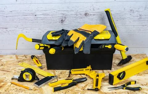 Yellow construction instruments and a tool box on a wooden background. Foto stock