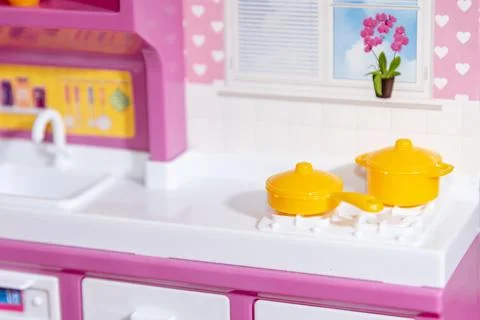 Yellow cookware kitchenware pans on stove in stylish design pink doll home ap 库存照片