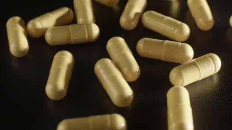 Yellow CoQ10 Capsules on Rotating Platform Video stock 332367760