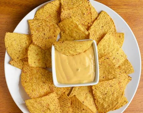 Yellow corn chips served with a cheese dip Stock Photos