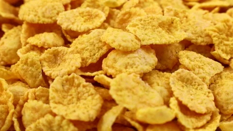 Yellow corn flakes falling down close up. Cereal bowl for morning breakfast Stock Footage 245922140