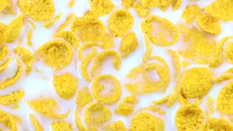 Yellow corn flakes with white milk circle rotation close up top view Stock Footage 244312911