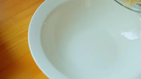 Yellow corn flour rolls in a white plate from the jar on a wooden table. Closeup Stock Footage 127780737