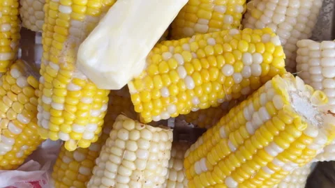 Yellow corn kernels and butter gleam in light Stock Footage 344906082