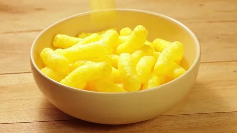 Yellow corn sticks being poured into a white bowl on a rustic table... Stock Footage 338212364
