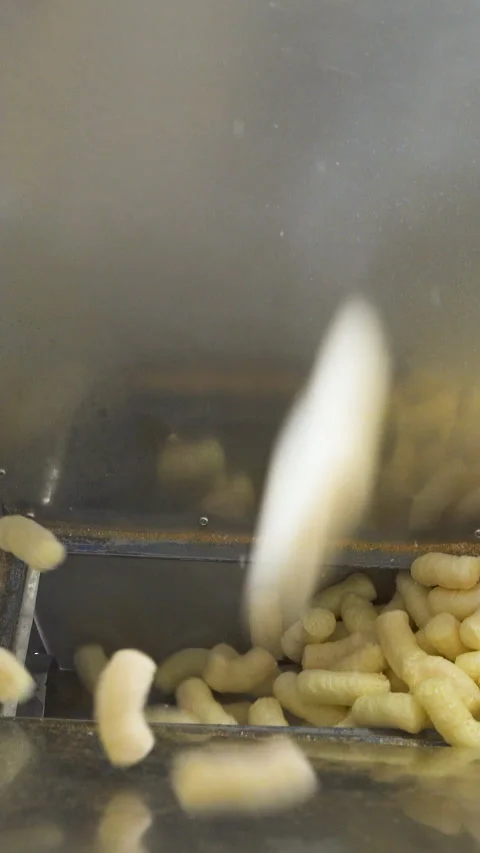Yellow corn sticks falling down into a metal container. Automatic production Stock Footage 277649046