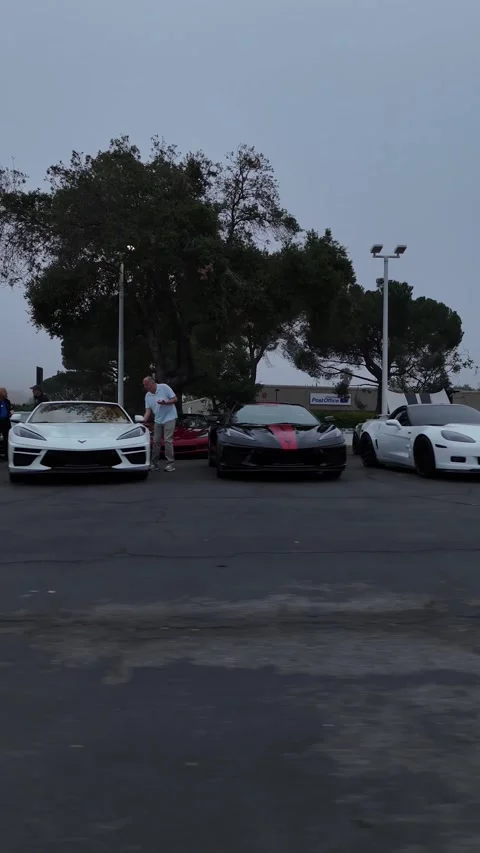 Yellow Corvette with hood open on display at car meet, drone view Stock Footage 346732463