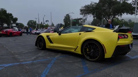 Yellow Corvette Z06 side profile at car meet, drone footage Stock Footage 346733586