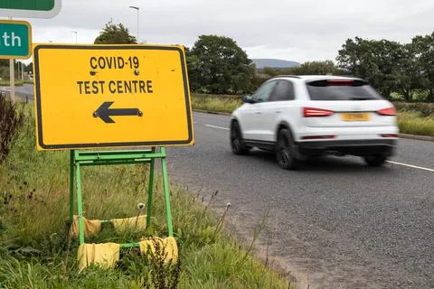 Yellow Covid 19 Test Centre road sign at the side of highway Stock Photos