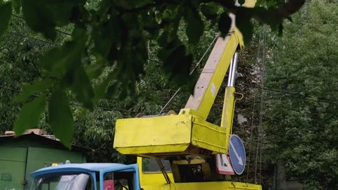 Yellow crane collecting large tree logs, municipal cleanup work after natural di Stock Footage 281577016