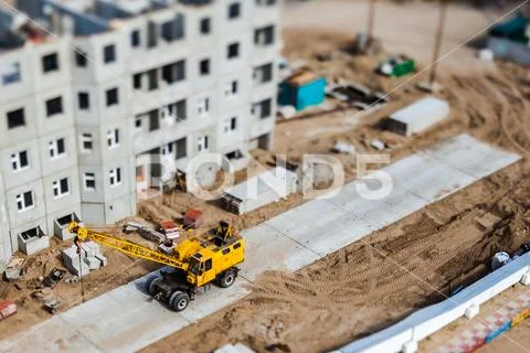 Yellow crane on construction site. Tilt-shift photo. Stock Photos