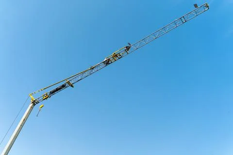 Yellow crane doing work and moving weights. Construction concept. Stock Photos