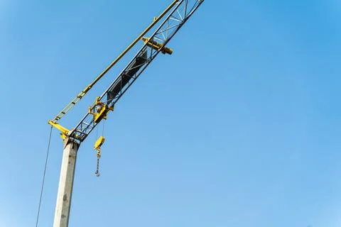 Yellow crane doing work and moving weights. Construction concept. Stock Photos