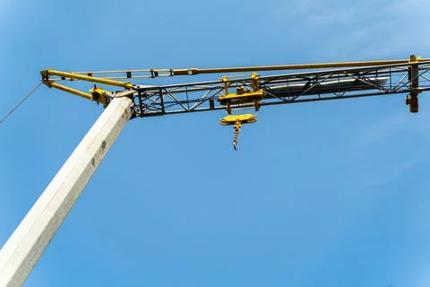 Yellow crane doing work and moving weights. Construction concept. Stock Photos