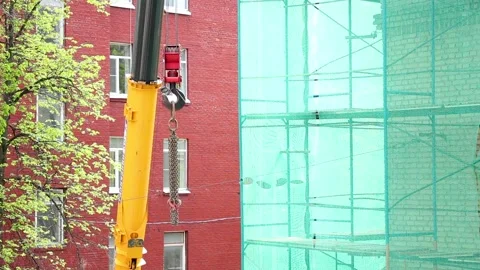 Yellow crane hook with metal chain hanging in front. Russia - 04 September 2026 Stock Footage 341833912