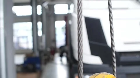 Yellow crane hook rotating unfolding, revealing strong metal structure. Video stock 313815207