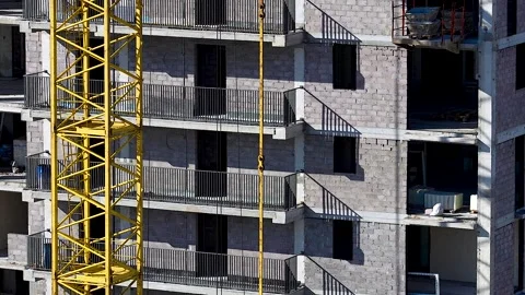 A yellow crane next to an unfinished building. Stock Footage 340896903