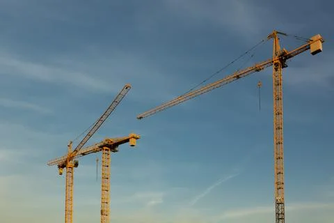 Yellow cranes on the background of the blue sky Stock Photos