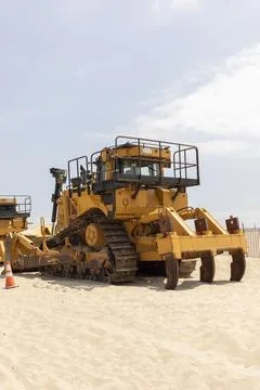 Yellow Crawler Dozer On Sandy Beach, Blue Sky On Background. Bulldozer Builds Stock Photos