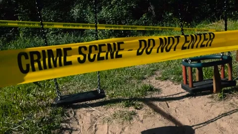Yellow crime scene tape pulled playground empty swings during a sunny day Stock Footage 312665065
