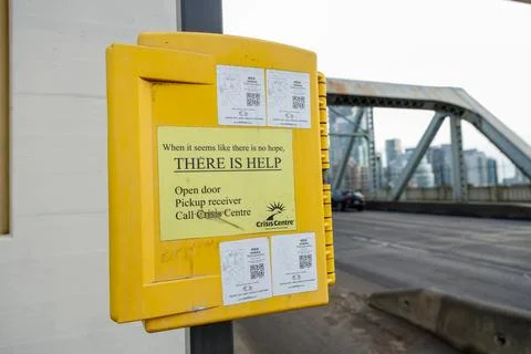 Yellow crisis intervention box reading THERE IS HELP mounted on column at V.. Stock Photos