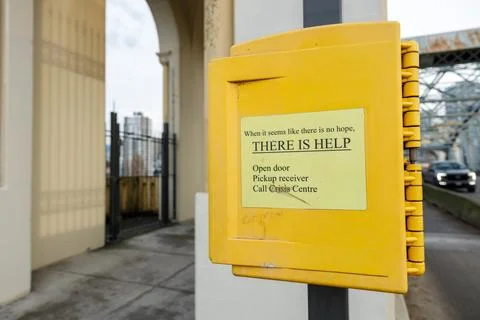 Yellow crisis intervention box reading THERE IS HELP mounted on column at V.. Stock Photos