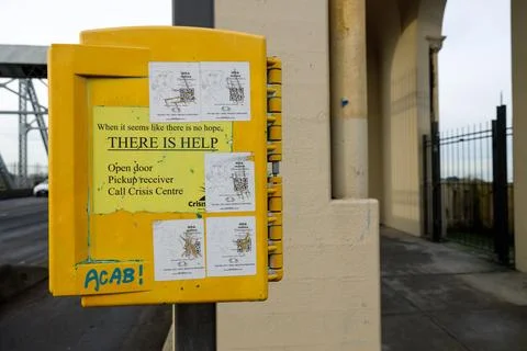 Yellow crisis intervention box reading THERE IS HELP mounted on column at V.. Stock Photos