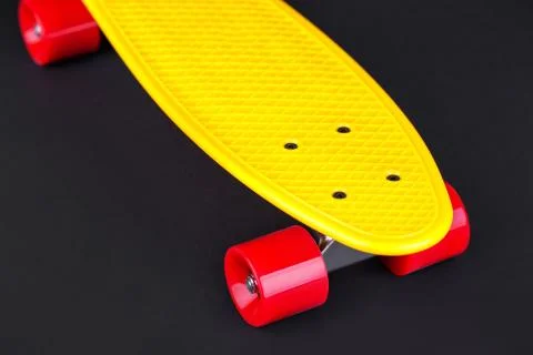 Yellow cruiser penny plastboard with red wheels Stock Photos