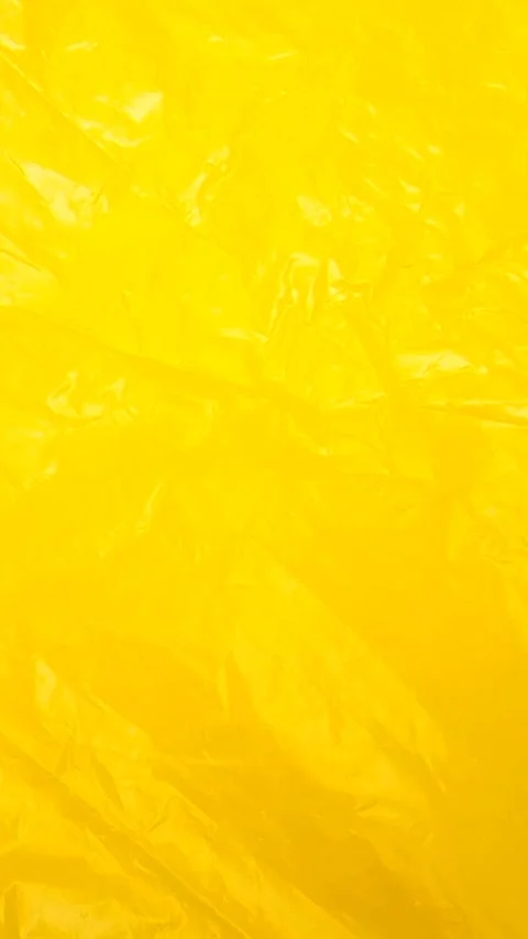 Yellow crumpled plastic bag texture background rotating. HDPE Polyethylene Stock Footage 316382098