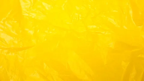 Yellow crumpled plastic bag texture background rotating. HDPE Polyethylene Stock Footage 316382155