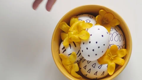 Yellow cup on a white background with Easter eggs. female hand removes a cup Stock-Footage 108197178