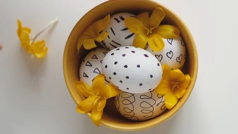 Yellow cup on a white background with Easter eggs. female hands move the cup Stock-Footage 108197210