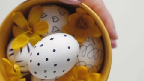Yellow cup on a white background with Easter eggs. female hands move the cup Vidéo 108197257