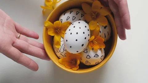 Yellow cup on a white background with Easter eggs. female hands move the cup Vídeo Stock 108715652