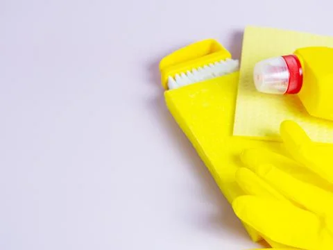 Yellow detergent bottle with sponge on folded yellow napkin and yellow rubber Stock Photos