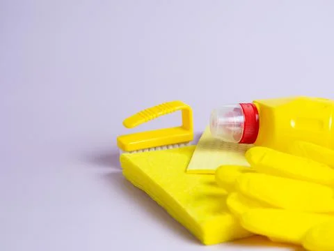 Yellow detergent bottle with sponge on folded yellow napkin and yellow rubber Stock Photos