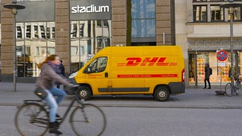 Yellow DHL van delivering parcel in city Stock Footage 114282963