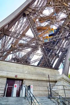 Yellow diagonal elevator inside the metal support of the Eiffel Tower 写真素材